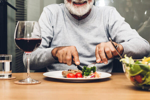 ステーキを食べるシニアの写真