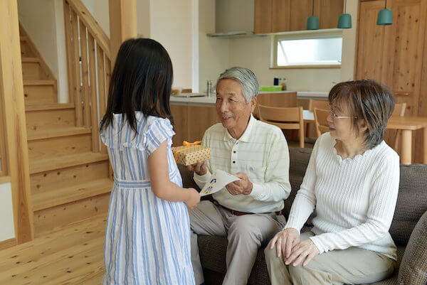 孫が祖父母にプレゼントを渡す様子